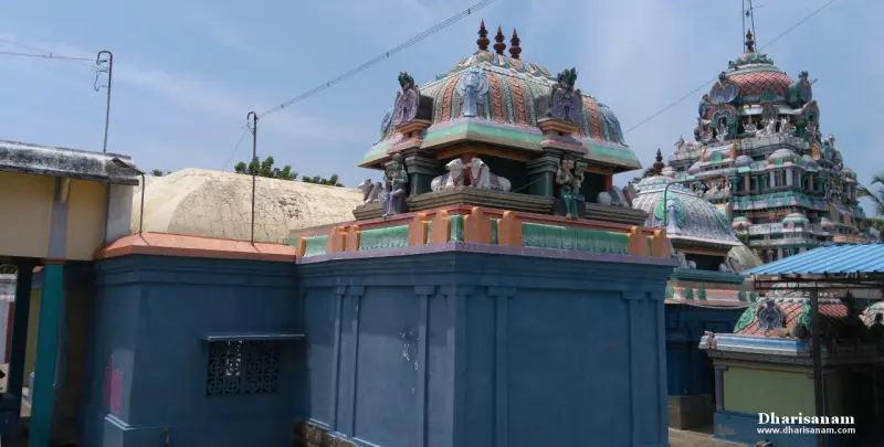 A painted dome over blue walls with several smaller shrine roofs and a taller tower behind.