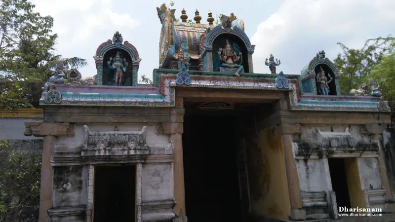 Stone gateway topped by a small painted tower with deity figures