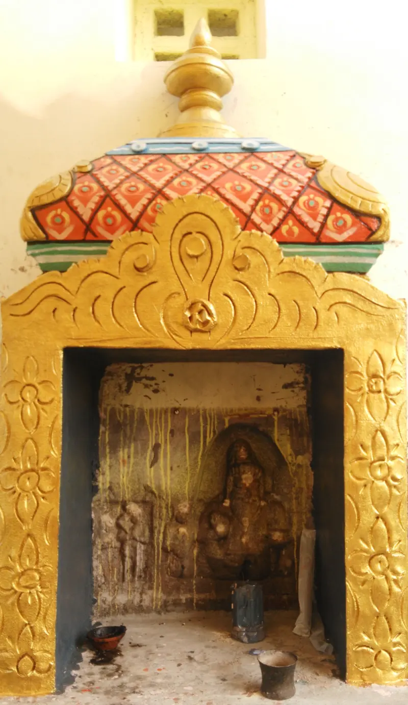 Worn carved gods in a small gold-framed shrine