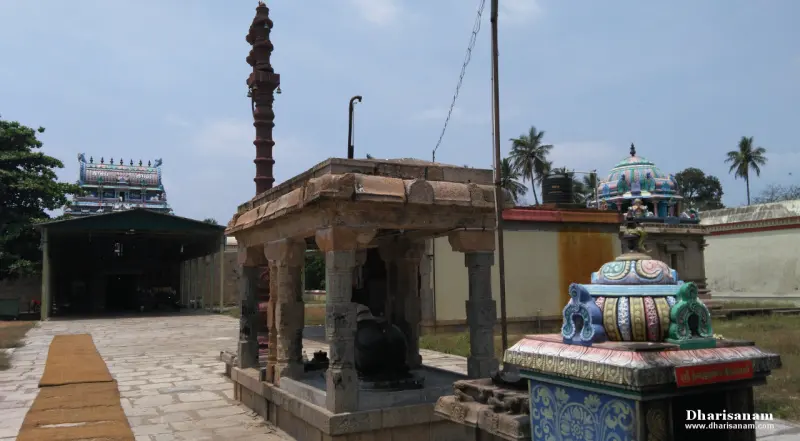 Nandi under a pillared shelter with tall flagstaff and shrines around