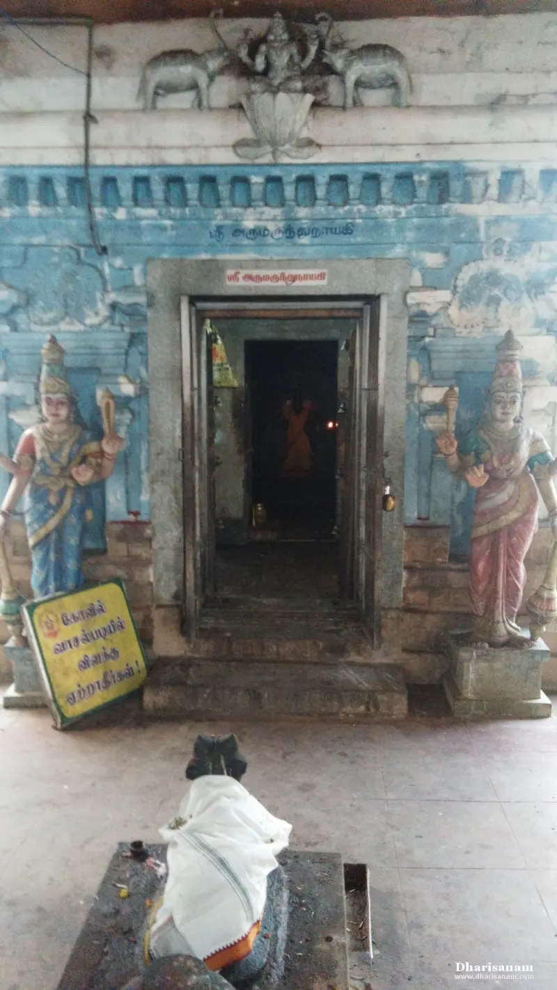 Shrine doorway with a name board above it, two painted figures at its sides and a Nandi before it