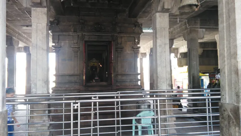 Granite shrine behind steel railings between carved pillars