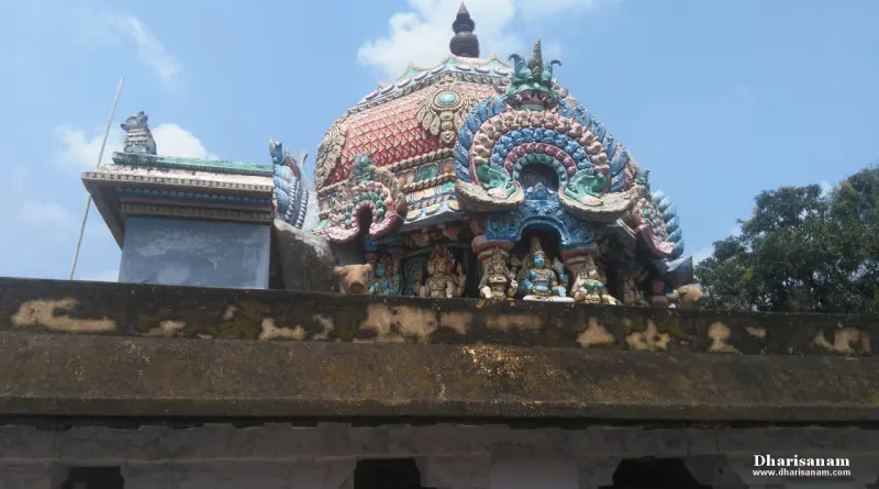 Close view of a colourful domed shrine roof with sculpted figures under a blue sky