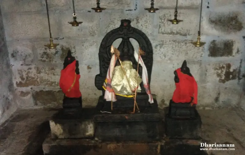 A central idol under an arch, in gold cloth, with two smaller idols in red cloth on either side.
