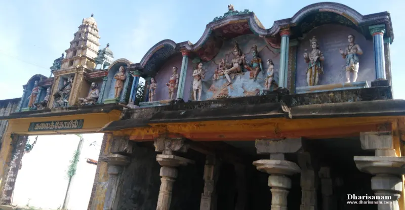 Painted stucco figures above a pillared gateway, with a tower rising at the left