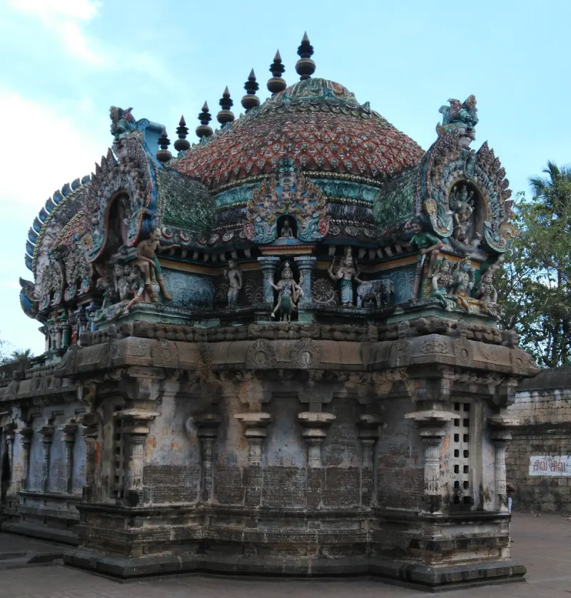 Domed sanctum roof with a row of finials, seen from a corner, with inscriptions on the wall