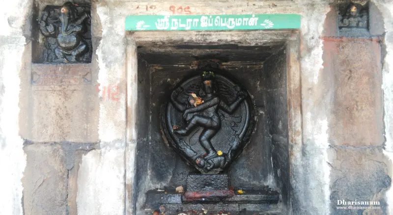 A black stone Natarajar dancing in a niche, with a Ganesha relief at the upper left