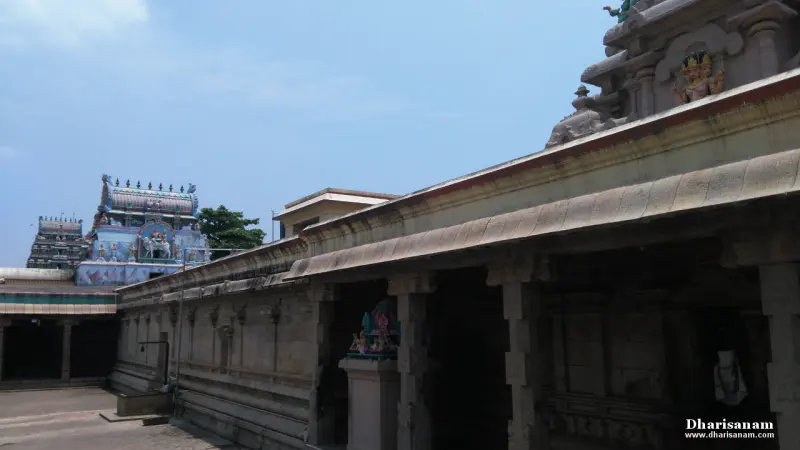 Long stone corridor with carved pillars and sculpted tower beyond