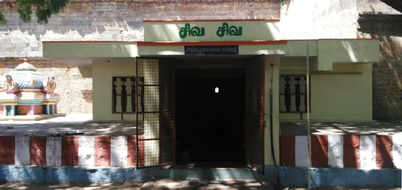 A plain shrine porch under a Tamil board reading Siva Siva, with a dark doorway and an iron grille.