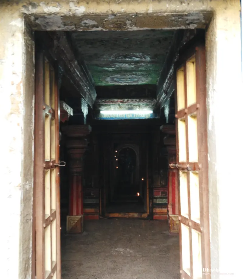 Open lattice doors lead into a dim pillared hall with a painted ceiling and a lamp-lit shrine at the end