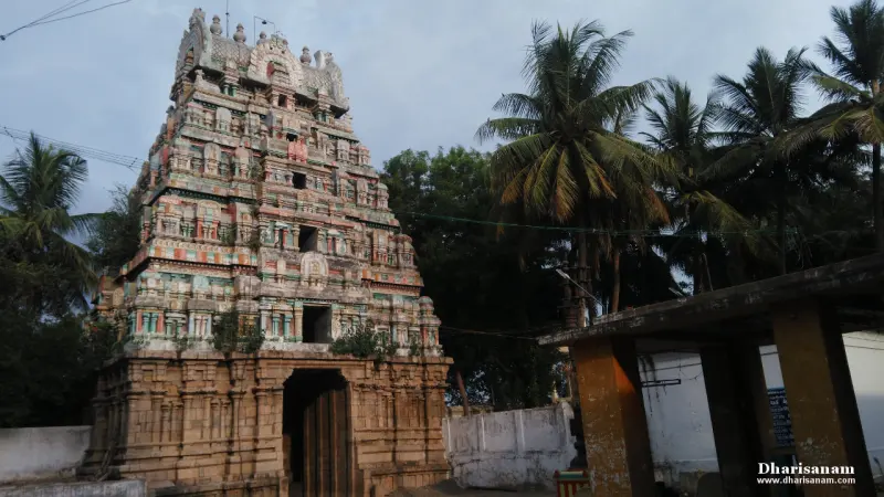 Painted five-tiered tower with an entrance passage beside palm trees
