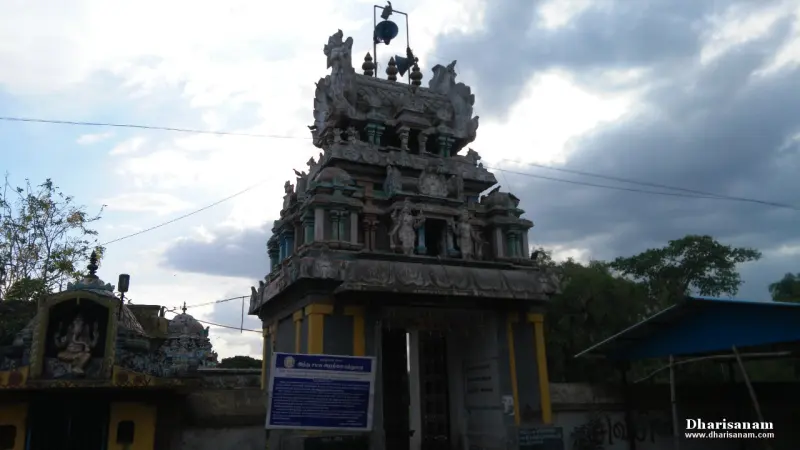 A two-tiered sculpted tower over a doorway, with a blue notice board in front.