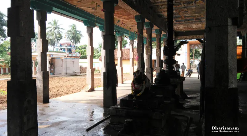 Stone-pillared corridor with a shrine and ploughed ground seen on the left