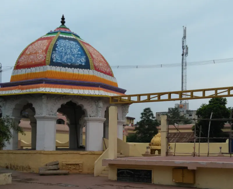 Colourful dome on white pillars in an open yard