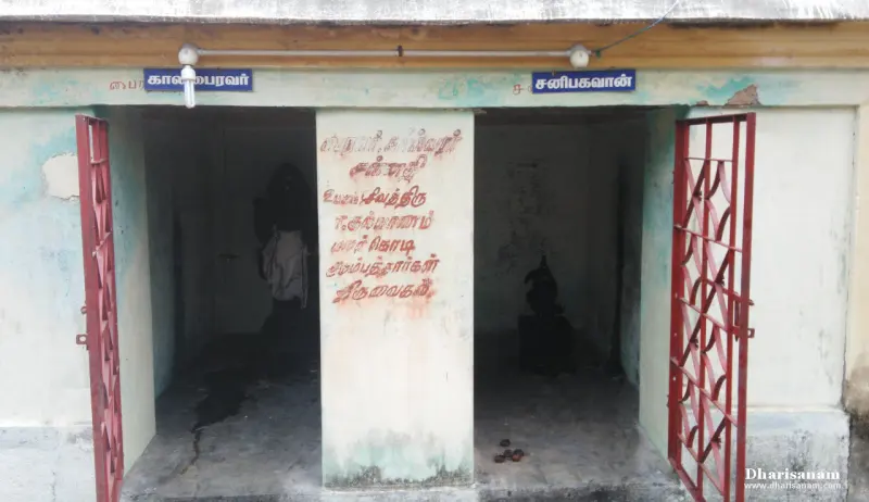 Two small shrines side by side with red gates, under blue name boards for Kalabairavar and Saneeswarar.