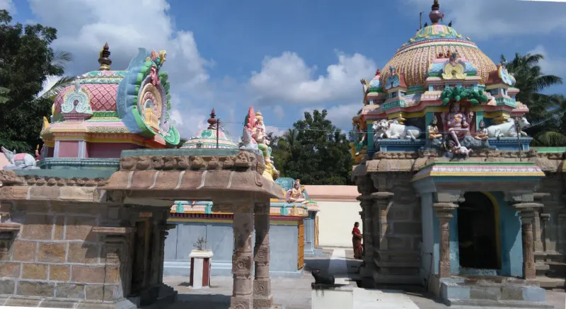 Colourful shrine domes and stucco figures rising above stone walls, with a Nandi in the foreground