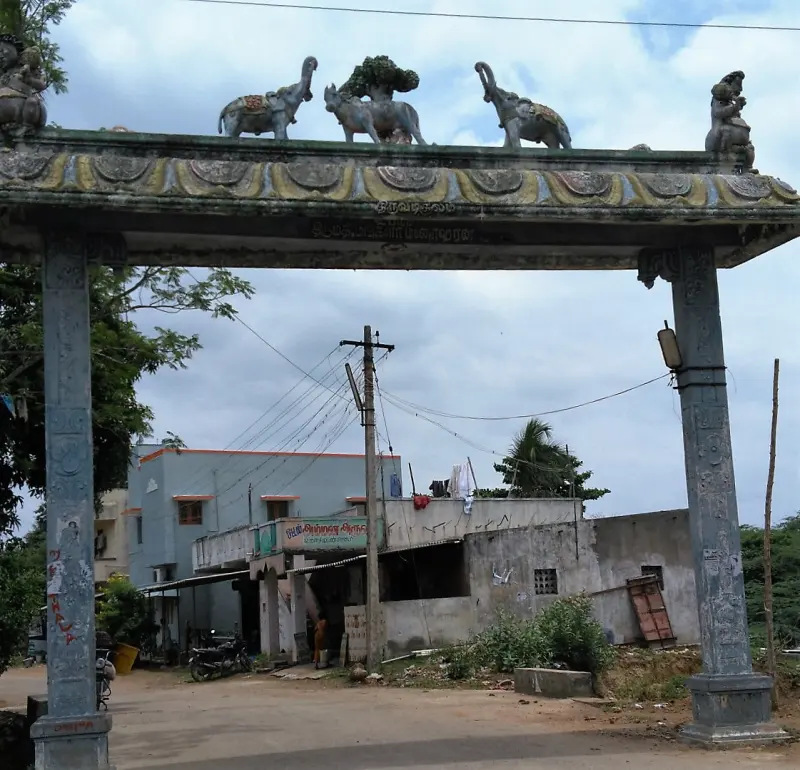 A stone arch over a road, with elephants, a bull and a tree sculpted along its top beam.