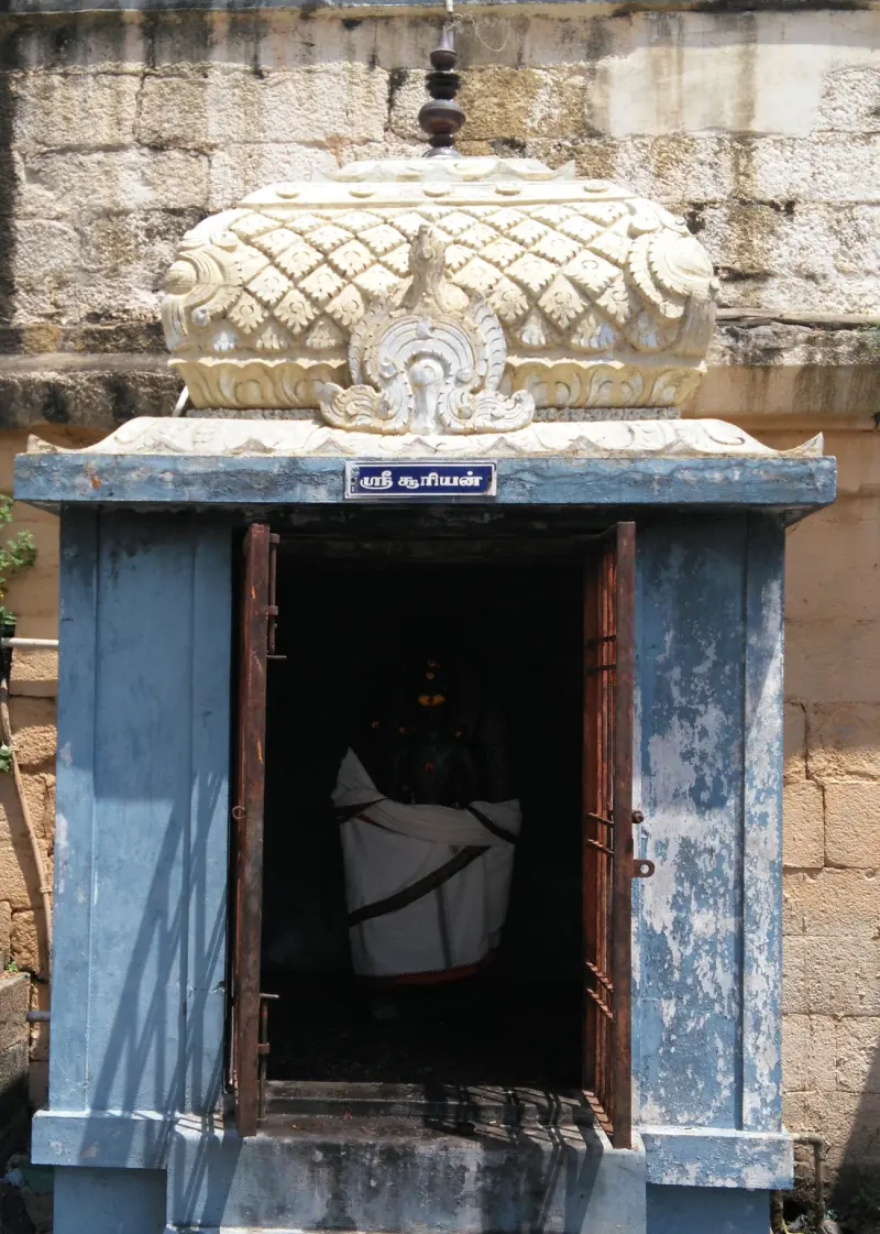Small shrine with a carved white roof and an idol in white cloth inside