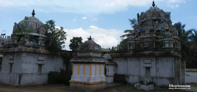 Two domed towers and a small yellow-pillared shrine between them, seen from the courtyard.