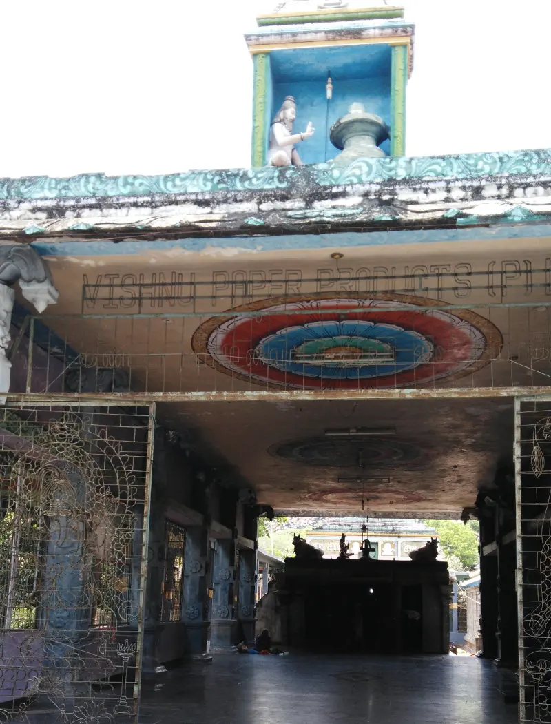 A long covered hall with a round painted pattern on the ceiling and a small shrine at the far end.
