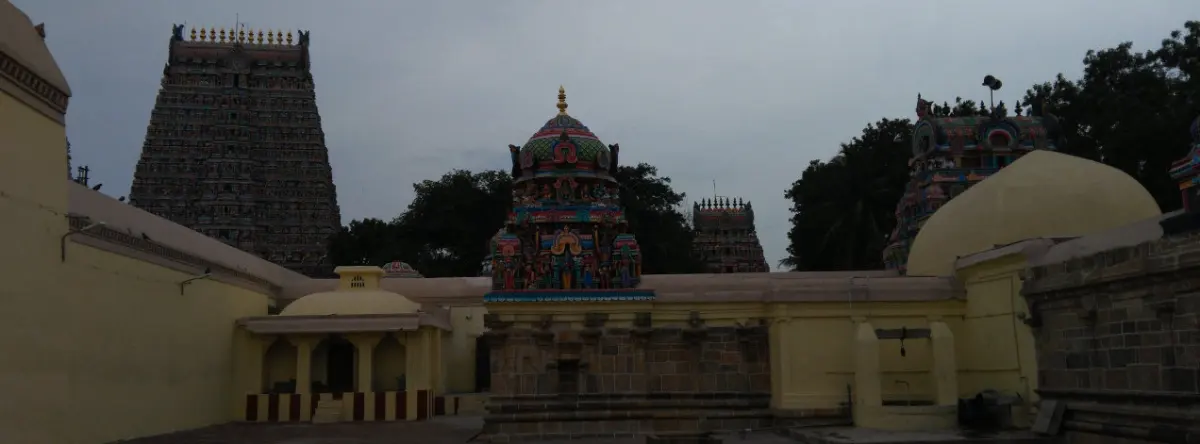Dark gopuram and painted vimana rising over yellow walls