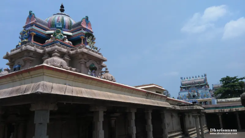 Sculpted dome tower in front with a tall blue tower in the distance