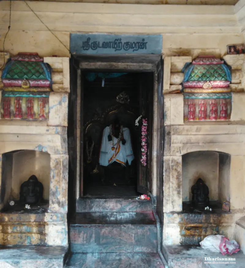 A shrine doorway with painted niches and idols inside