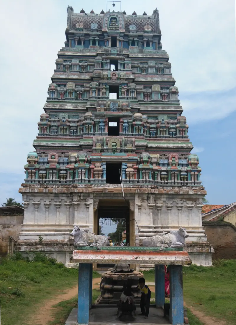 A tall five-tier gopuram with two Nandi bulls on a platform before it