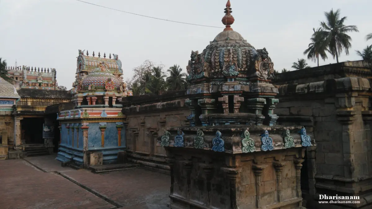 Small painted shrines and a domed tower around a paved courtyard, under an overcast sky