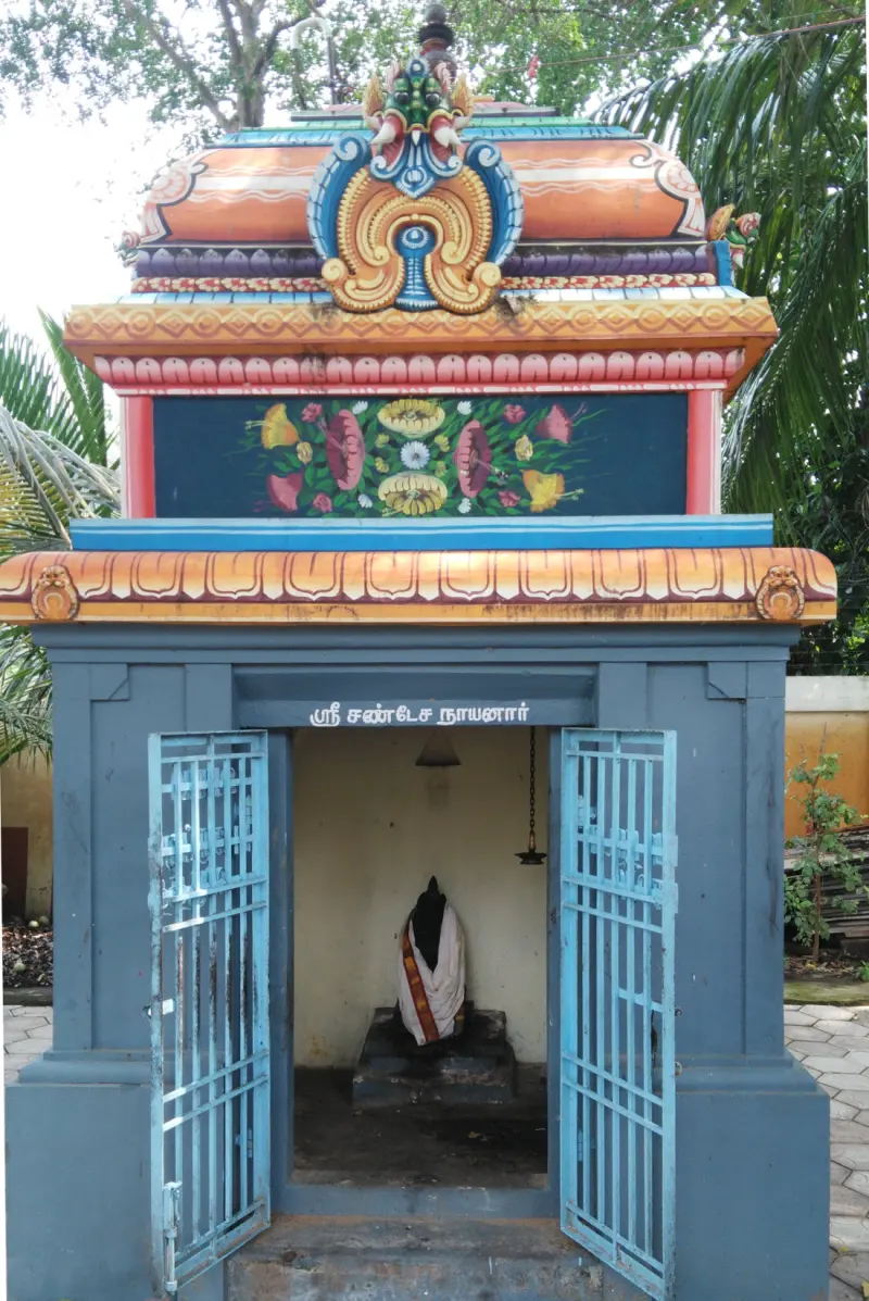 Small blue shrine with open gates and a painted tower