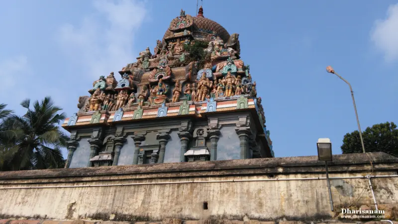 A colourful tower crowded with sculptures above a wall