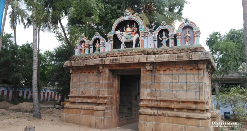 Stone gateway with painted stucco figures, including a bull, above its roof