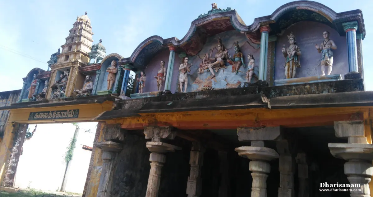 Painted stucco figures above a pillared gateway, with a tower rising at the left