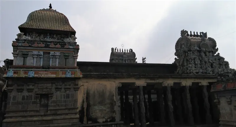 Stone gopurams and hall roof rising above the outer wall