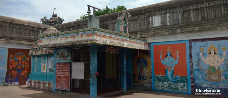 A small shrine with painted panels on the wall beside it, one showing a fish-bodied figure