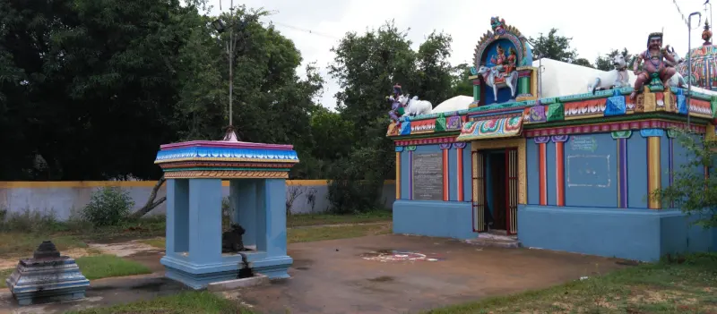 A small blue pillared mandapam with a Nandi, facing a blue shrine with painted figures