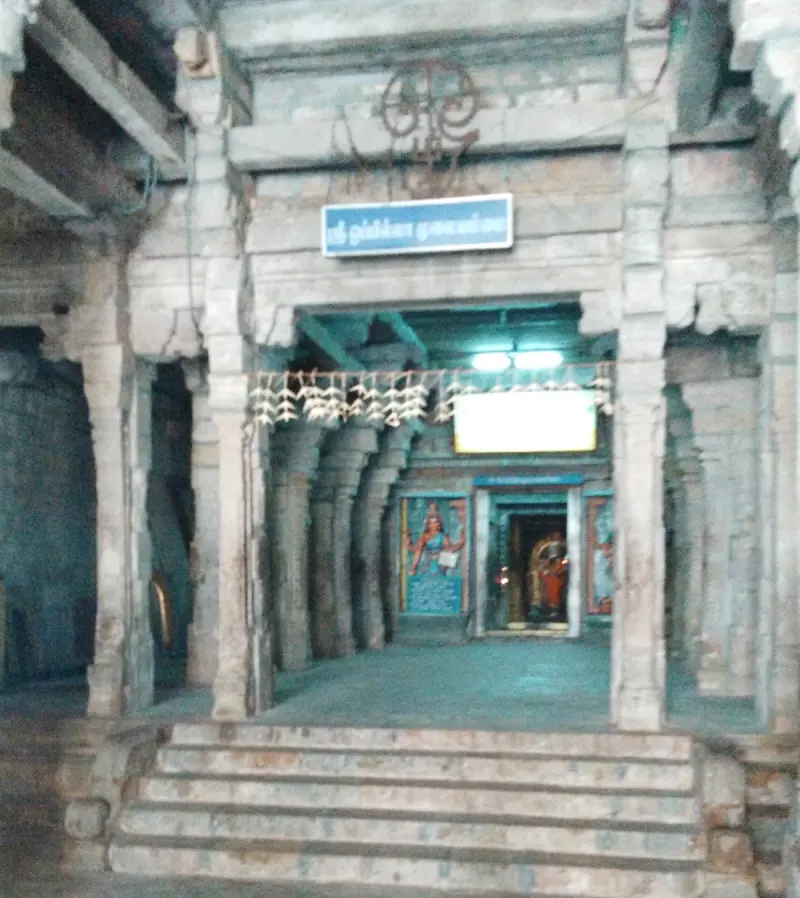 Stone steps lead up to a pillared hall with a blue Tamil board above the inner doorway