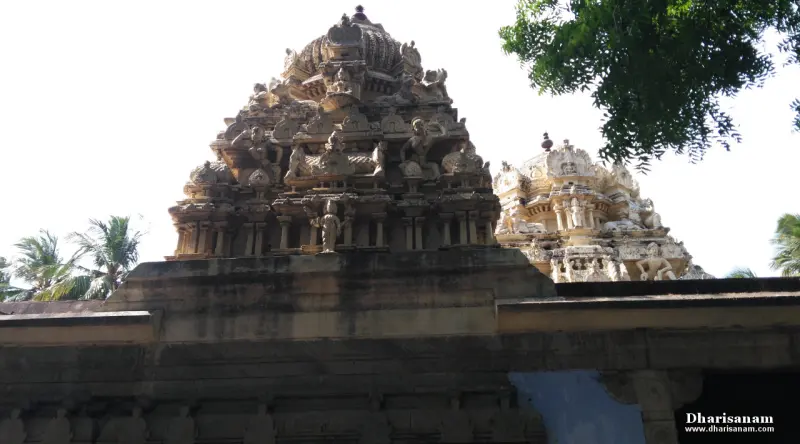 Two carved stone towers behind a high temple wall, one with a rounded top
