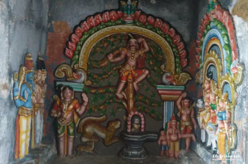Painted figures show a man in a tree above a lingam, a tiger beneath, and other figures at the sides