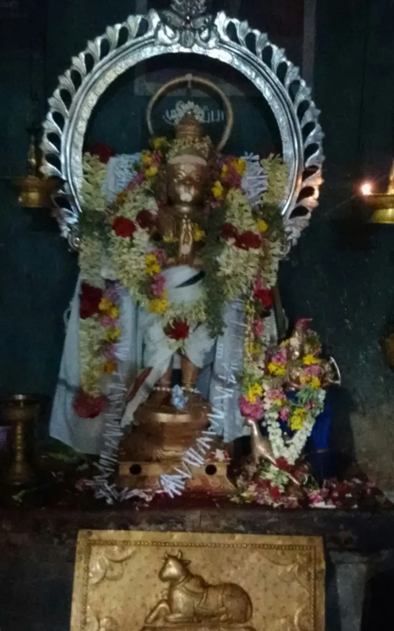 Garlanded Anjaneyar idol with folded hands under a silver arch