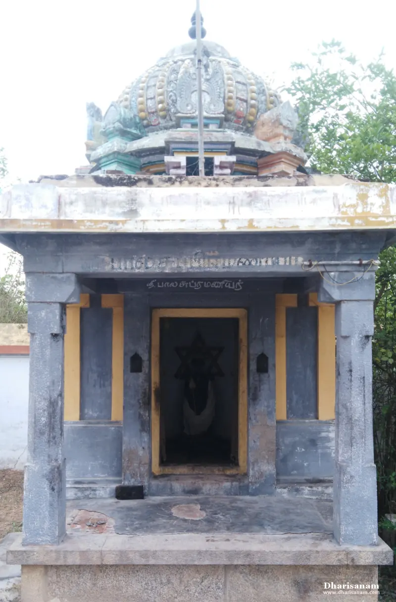 A small pillared shrine with a domed roof and a Tamil name board above its doorway.