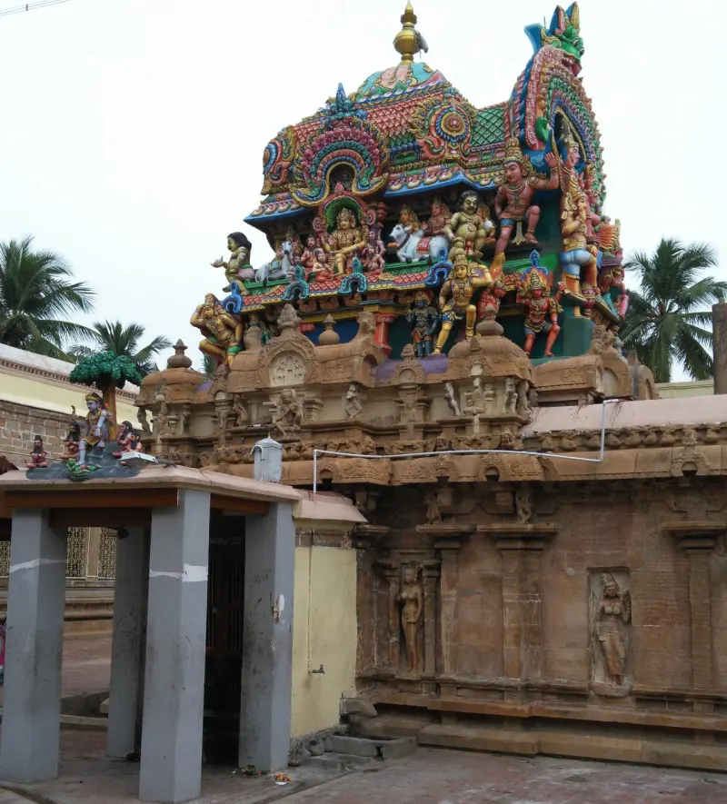 Stone shrine with colourful crowded statues on its tower top