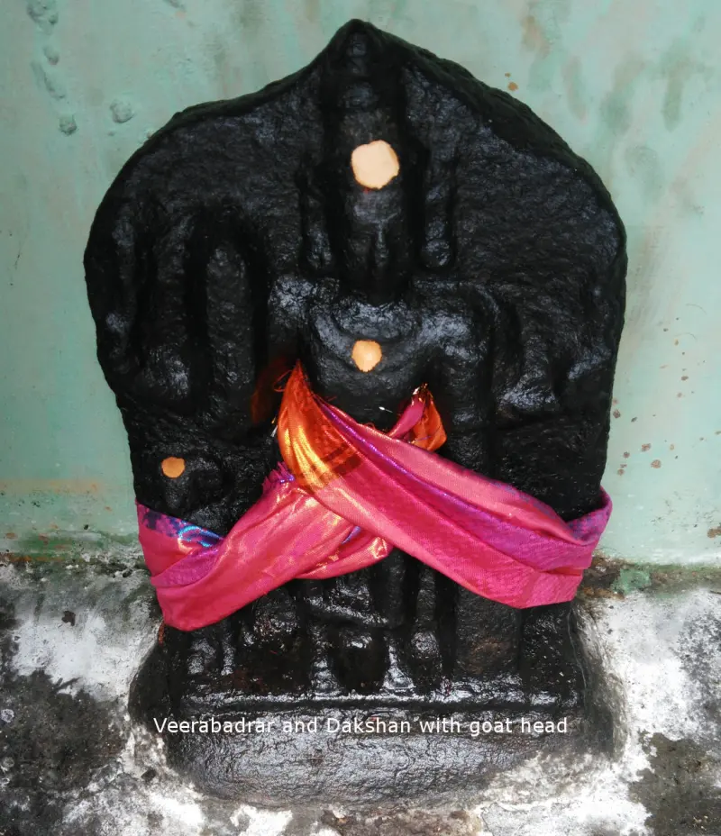 A black stone idol wrapped in a pink cloth, with a caption naming Veerabadrar and Dakshan.