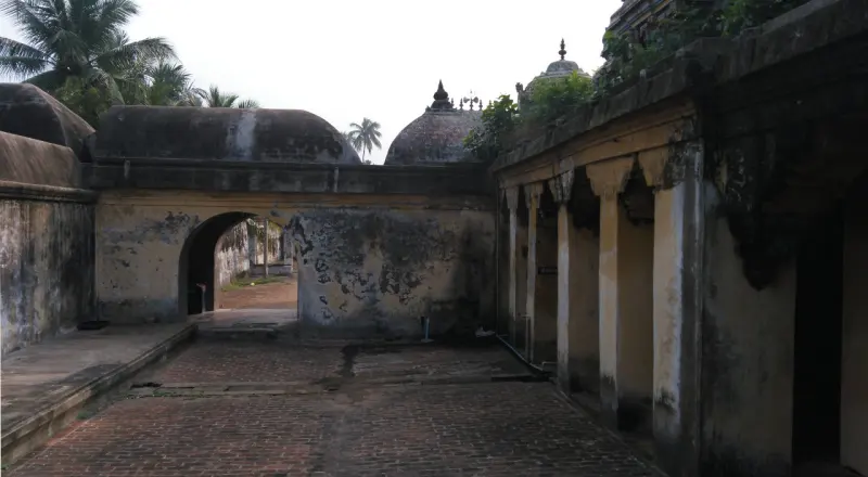 A courtyard with an arched passage and a pillared corridor