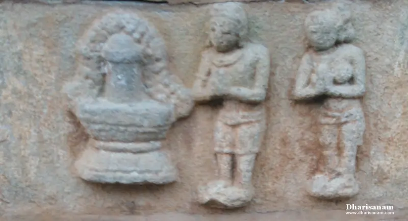 Weathered stone panel with a lingam on a base and two figures standing with folded hands