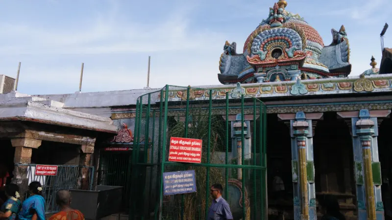 A gopuram and gated entrance with devotees