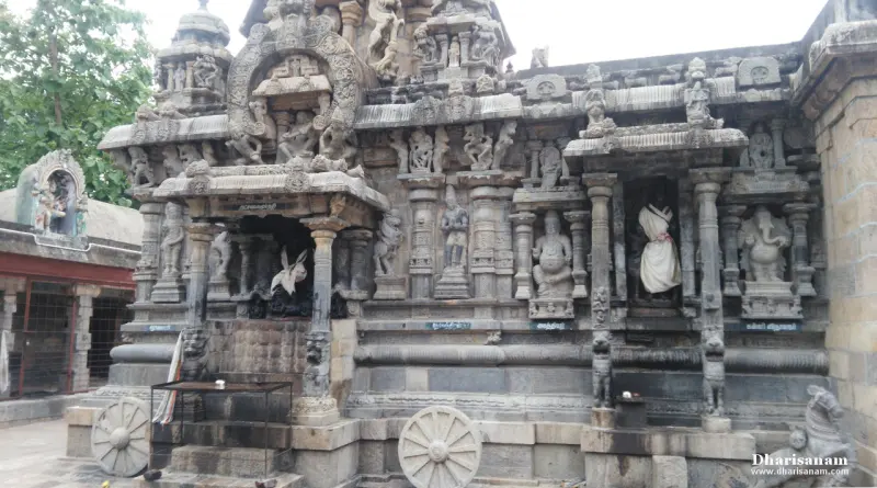 The outer wall of the chariot-shaped sanctum, carved with figures and niches, with stone wheels at its base.