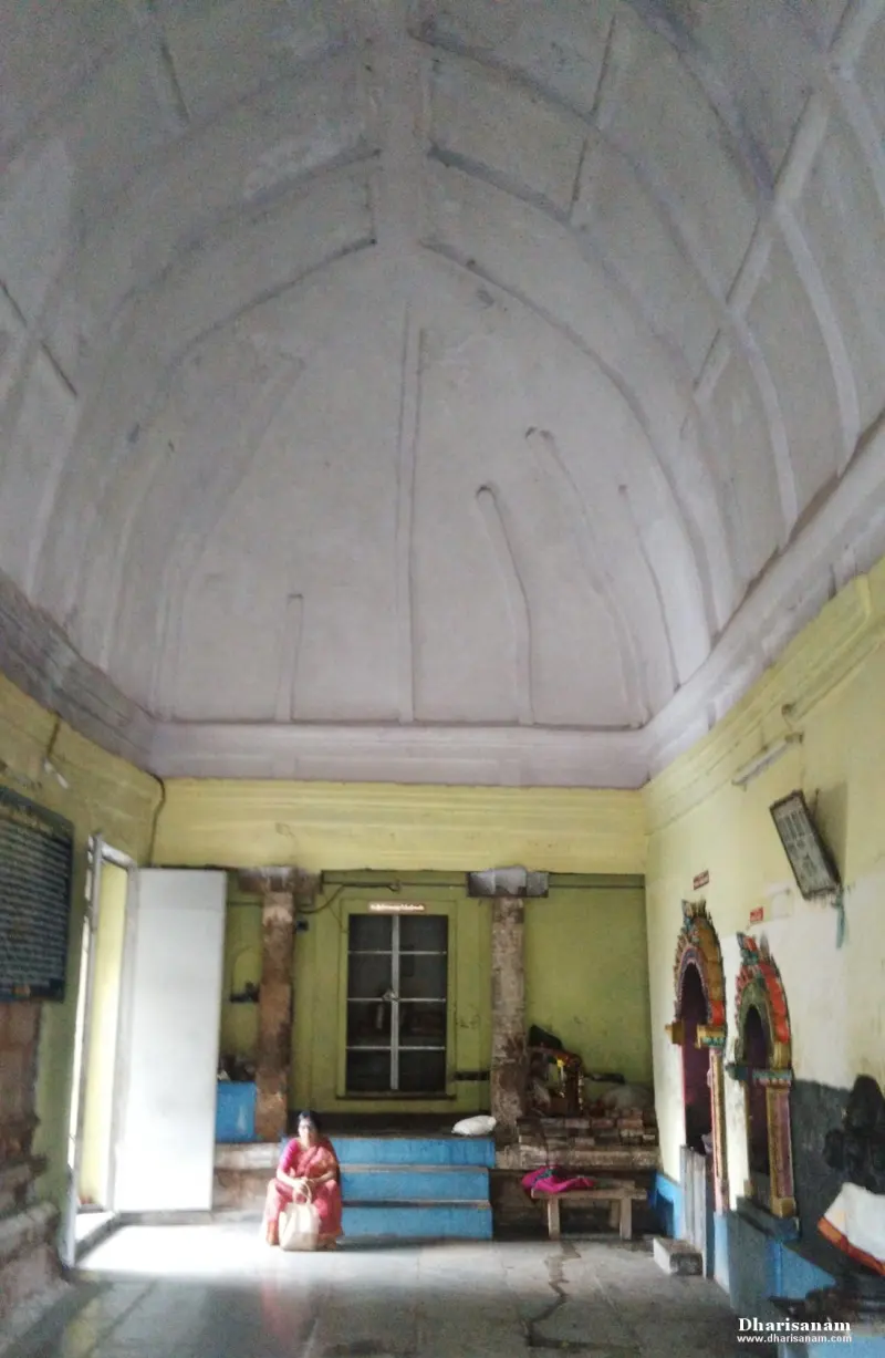 Tall hall with a white vaulted ceiling, blue steps and small shrines along the right wall