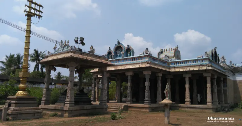 Gilded flag post beside an open pillared hall with decorated roof, under a blue sky