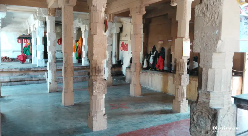 A hall of carved stone pillars with idols standing in a row along the right wall